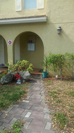 Front view of a building entrance with arches and pathway.