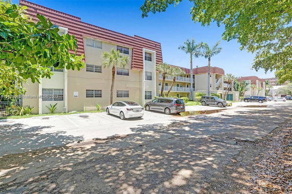Outdoor parking area in front of a multi-story residential building.