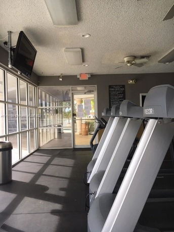 Interior view of a gym with treadmills and a television mounted on the wall.