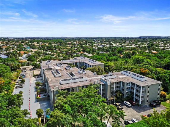 Aerial view of a residential complex surrounded by lush greenery and residential buildings.