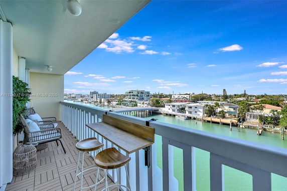 Balcony view over a waterfront area with buildings and clear skies