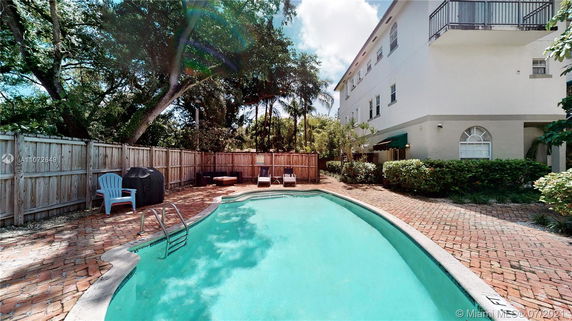 Outdoor swimming pool area next to a multi-story building.