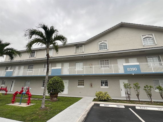 Front view of a multi-story building with parking in front.