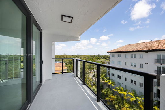 Balcony view showing surrounding buildings and greenery.