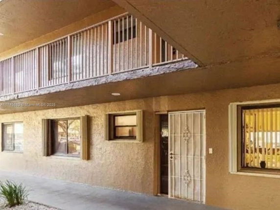 Front view of a building with metal railings and barred windows.