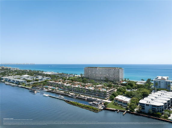 Aerial view of coastal residential area with multi-story buildings and waterway.