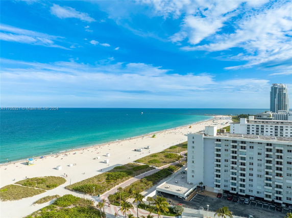View of a beachfront with buildings along the shoreline and the ocean in the background.