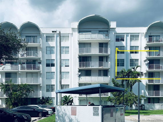 Front view of a multi-story apartment building with balconies.