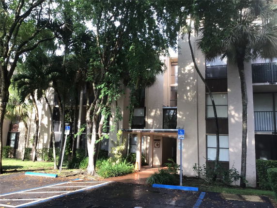 Front view of a multi-story building with surrounding trees.