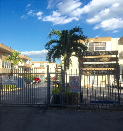 Front view of a multi-story condominium complex with a gated entrance.