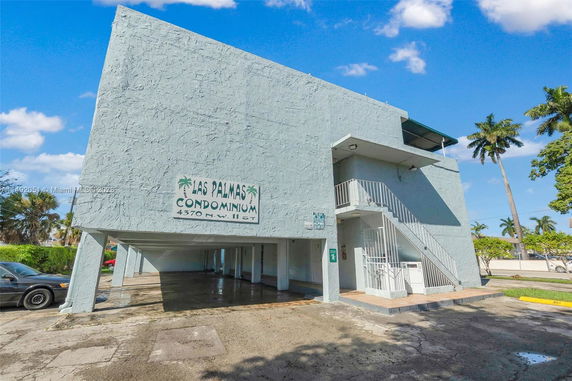 Front view of a condominium building with exterior stairs.