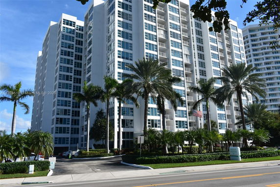 Front view of a multi-story residential building with large windows and balconies.