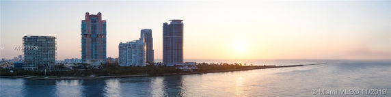 Panoramic view of high-rise buildings along a waterfront at sunset.