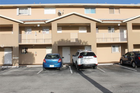 Front view of a multi-story building with a parking area in front.