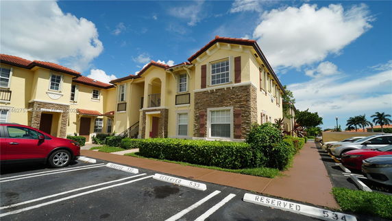 Front view of a two-story house with stone accents and reserved parking spaces.
