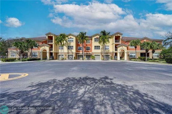 Front view of a multi-story residential building with multiple gables and arches.