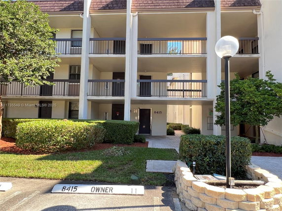 Front view of a multi-story apartment building with balconies.