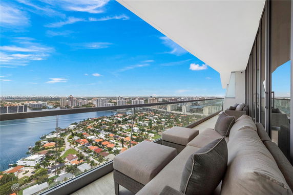 Panoramic view of a cityscape and waterway from a high-rise balcony.