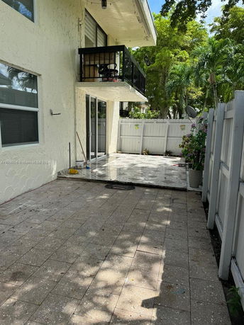 View of a house exterior with a balcony and a patio.