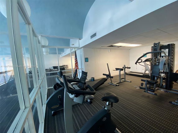 Interior view of a gym with exercise equipment and glass walls.