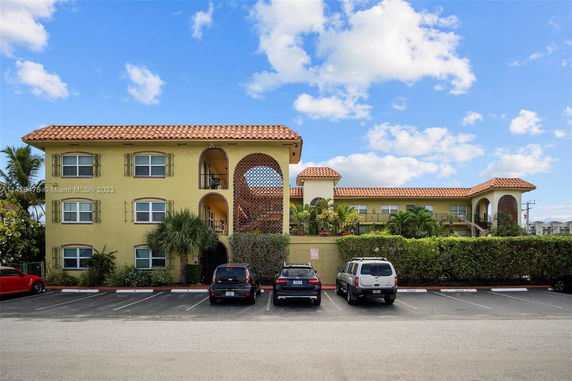 Front view of a two-story building with adjacent parking area.