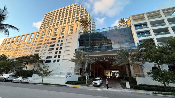 Front view of a large multi-story building with a modern design and glass facades.