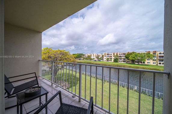View from a balcony overlooking a river and residential buildings.
