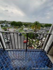 View from a balcony overlooking a parking lot and surrounding area.