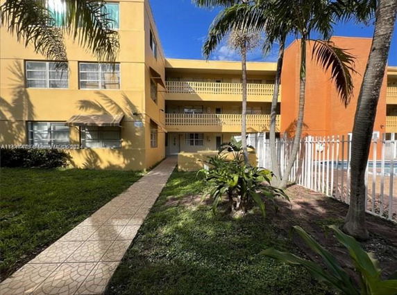 Front view of a multi-story apartment building with yellow and orange exterior walls.