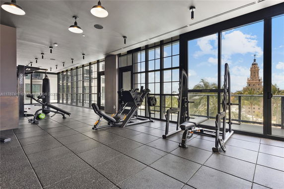 Indoor gym area with exercise equipment and large windows.