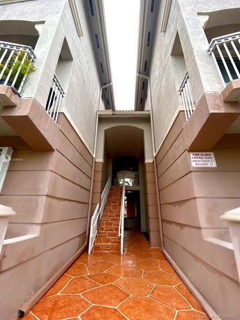 Front view of a multi-story building with an exterior stairway and balconies.