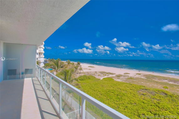 Panoramic view from a balcony overlooking a beach and ocean.
