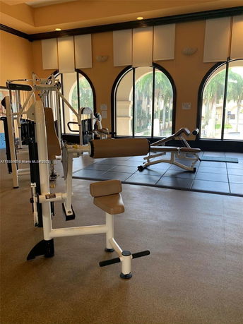 Indoor gym area with exercise equipment and large windows.