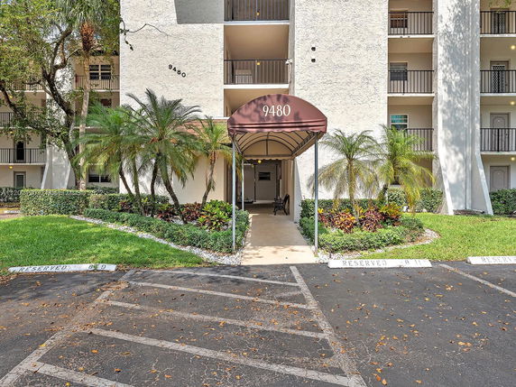 Front view of a multi-story building with balconies and a covered entrance.