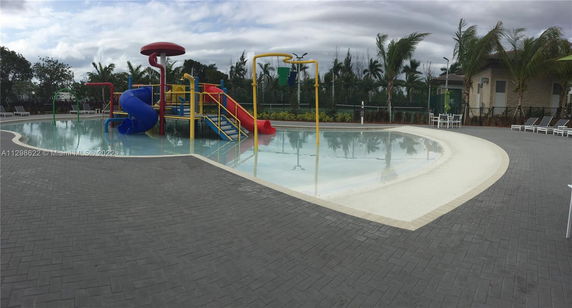 Outdoor swimming pool area with water slides and play structures.