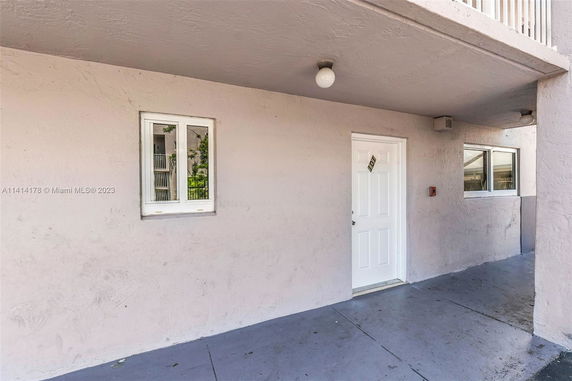 Front view of a building entrance with a labeled door and windows.