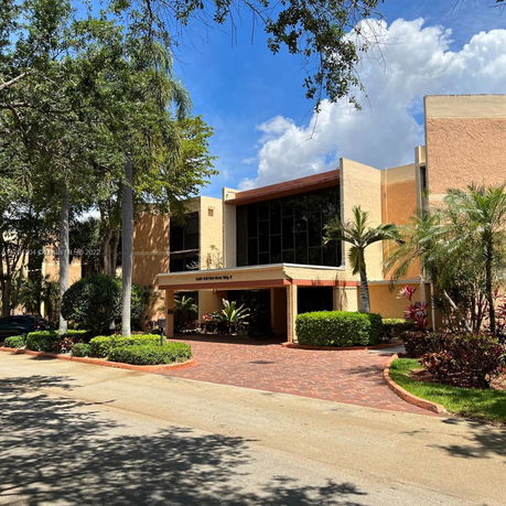 Front view of a multi-story building with large windows and a covered entrance.