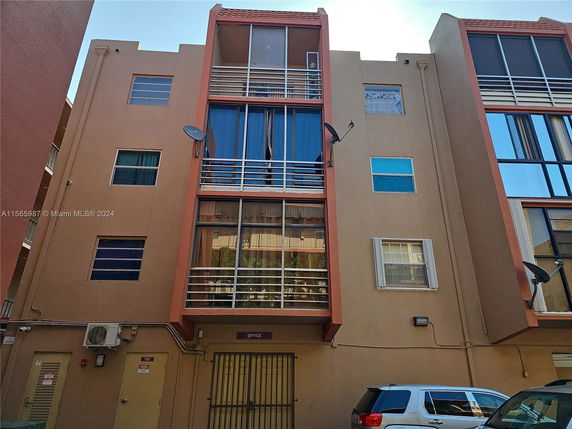 Front view of a multi-story building with large windows and balconies.