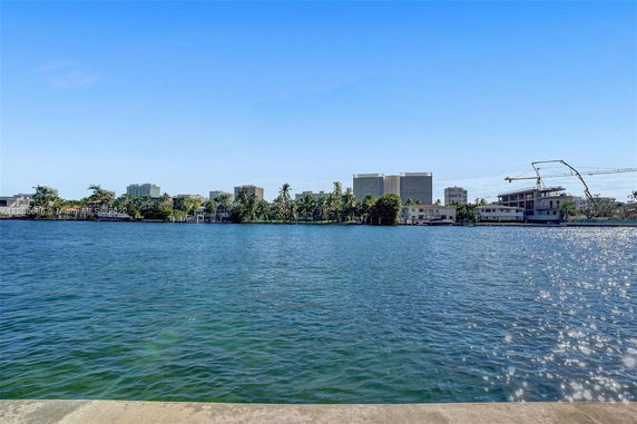 View across a body of water towards buildings in the distance.