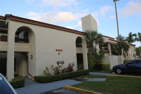 Front view of a two-story building with arched entrances and a tiled roof.