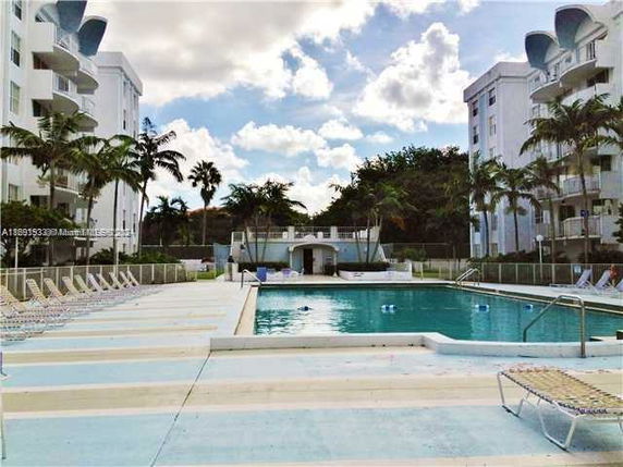 Outdoor swimming pool area surrounded by residential buildings.