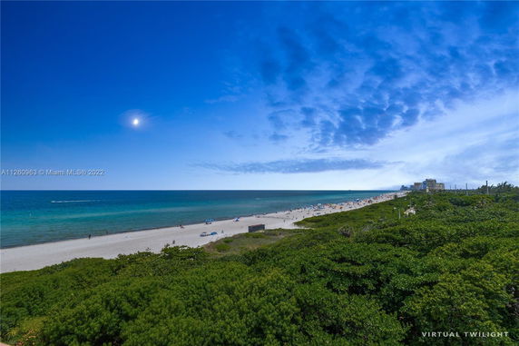Panoramic view of a beach with the ocean and horizon visible.