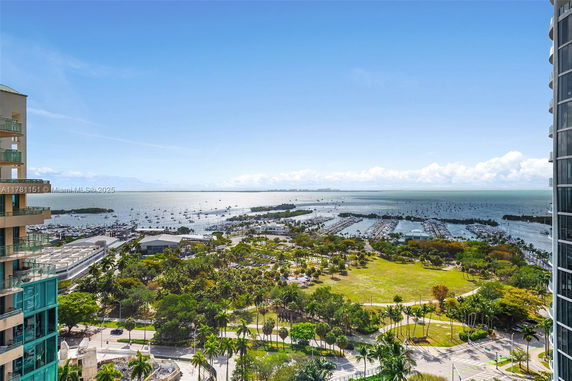 Panoramic view of a coastal area with boats and lush greenery.