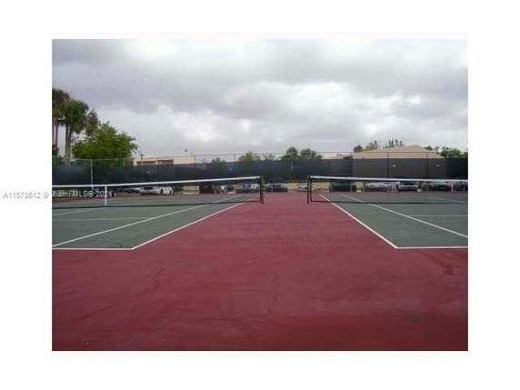 Tennis courts with surrounding buildings in the background.
