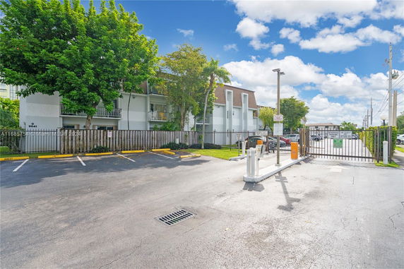 Outdoor parking area in front of a multi-story residential building.