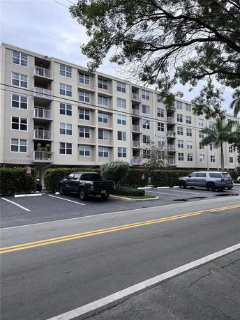 Front view of a multi-story apartment building with balconies.