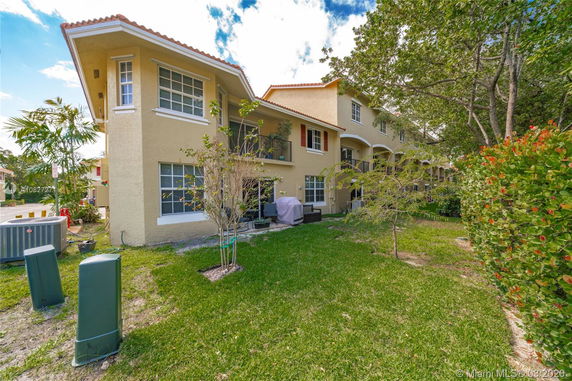 Side view of a two-story residential building with a small patio area.