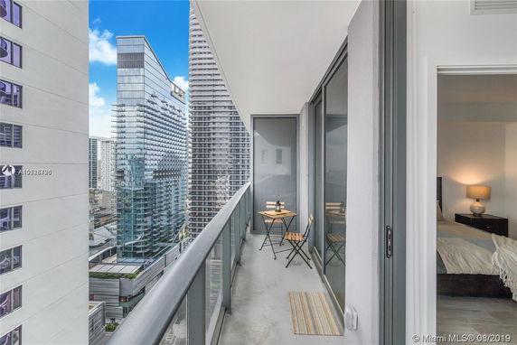 View from a high-rise balcony overlooking modern skyscrapers.