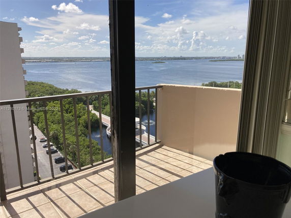 Panoramic view from a balcony overlooking a body of water and distant cityscape.