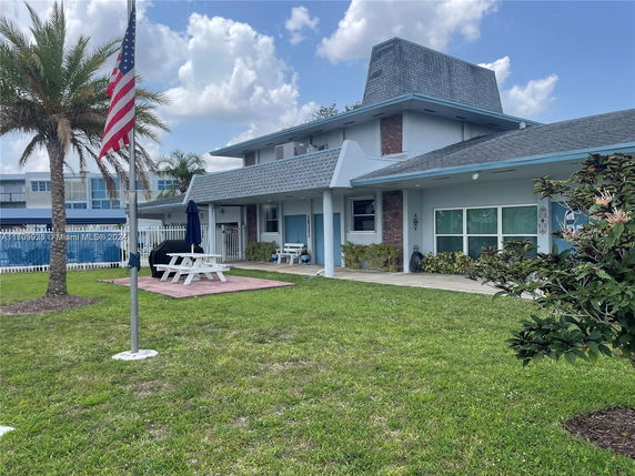 Front view of a two-story house with a unique roof design and a porch area.